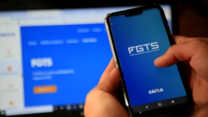 Pessoa segurando um celular com o aplicativo do FGTS aberto.